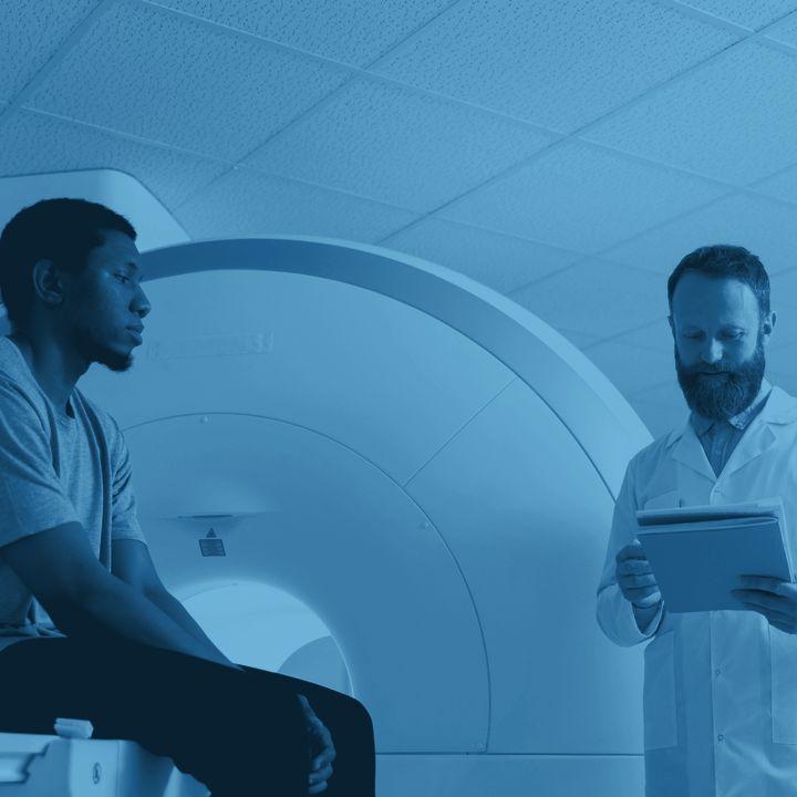 Clinician reviewing a chart beside a patient at a diagnostic scanner