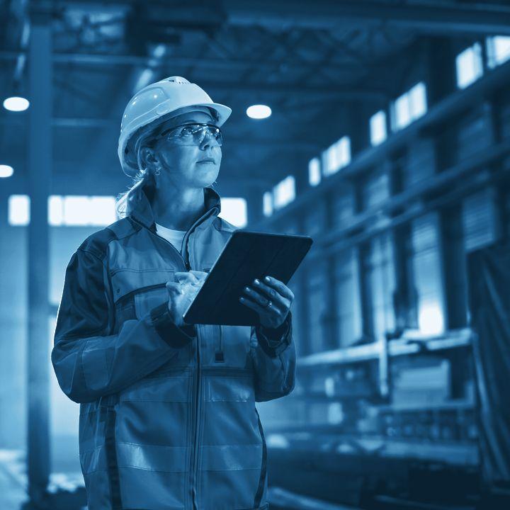 Plant engineer reading a tablet on the factory floor