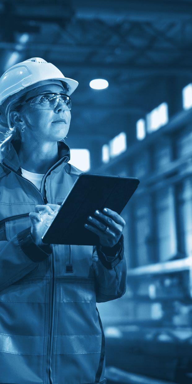 Plant engineer reading a tablet on the factory floor